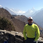 Joe Ashkar posing in front of a panoramic view of Ama Dablam & Everest.