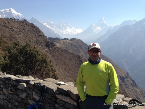 Joe Ashkar posing in front of a panoramic view of Ama Dablam & Everest.